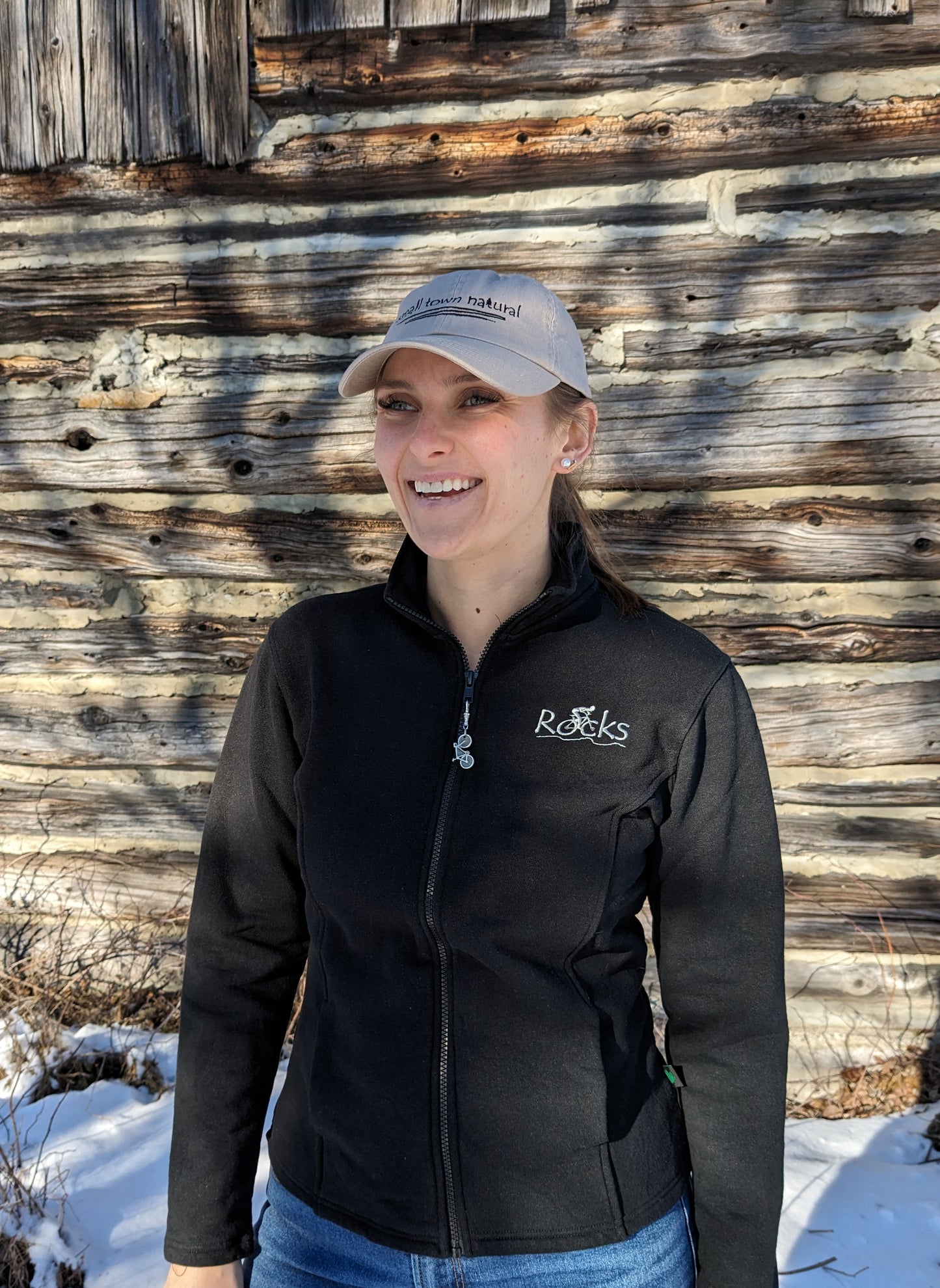 Our model Morgan is wearing black track jacket with 'Rocks' embroidered in light grey thread on upper left chest.'Rocks' is another original design from Small Town Natural. This design is a tribute to Mountain bikers. Each jacket includes a removable bicycle zipper pull made of Pewter hand made in the small town of Tweed, Ontario.